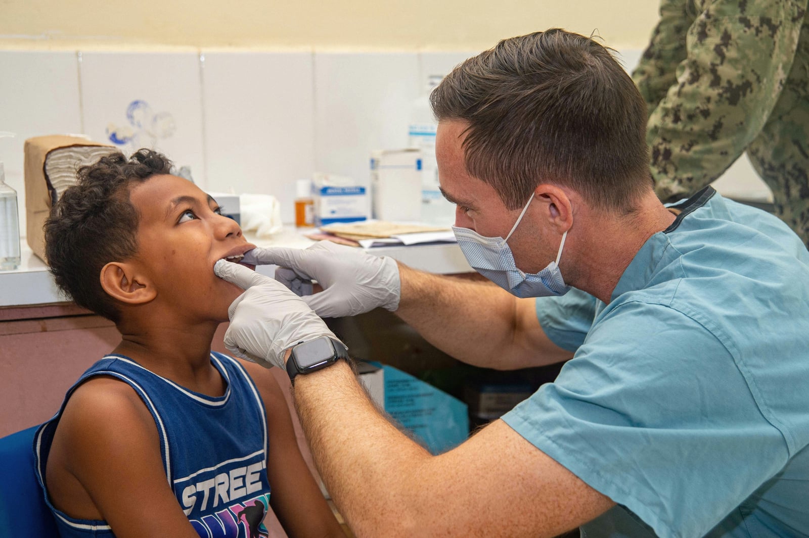 Dentist gently checking a young boy's teeth